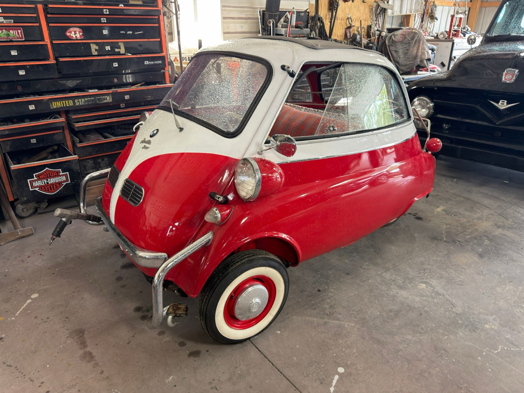 Red and white BMW Isetta bubble car inside the shop